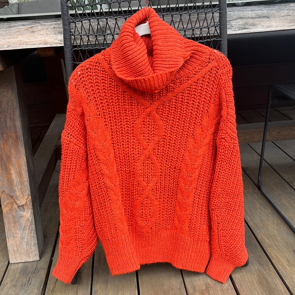 Bright orange/red knitted sweater with loose turtleneck
